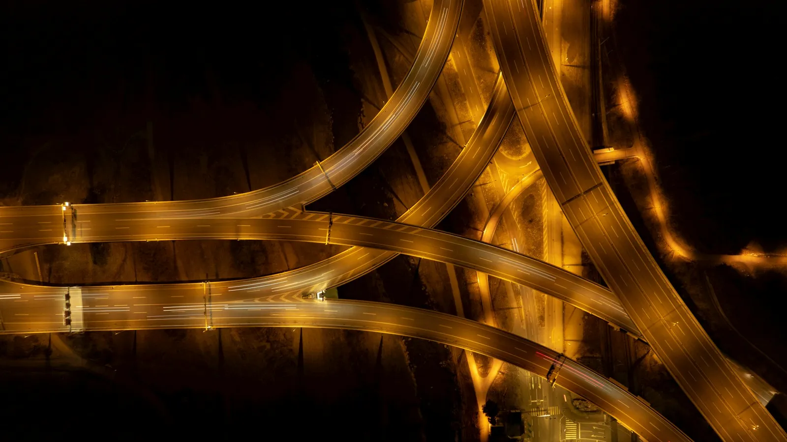 Aerial view of a road junction at night with light trails
